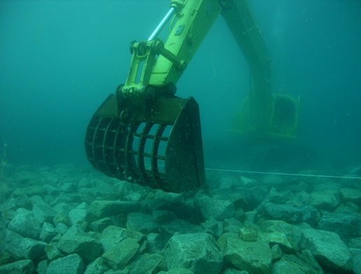 水中バックホウの基礎工事　基礎捨石・被覆石工